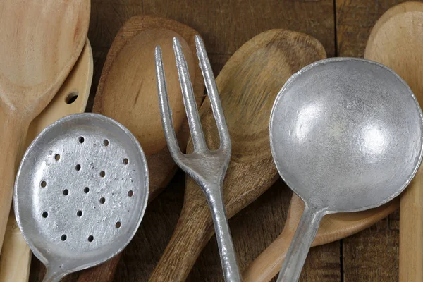 Wooden cutlery and cast aluminum cutlery on rustic wooden table, typical of all Brazilian cuisine