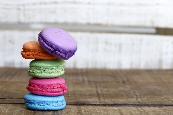 Macarons on rustic wood table, French candy meringue-based made with egg white, icing sugar, granulated sugar, almond powder or ground almond and food coloring