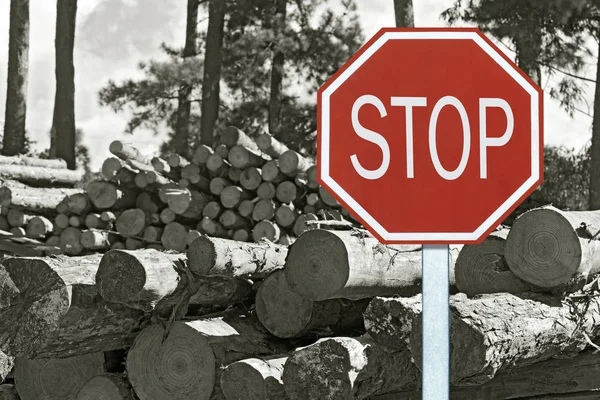 Sustainability concept: traffic stop sign in front of fallen trees, symbolizing call for help from the forest