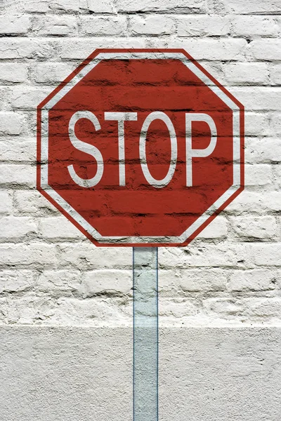 Stop traffic sign stamped on white brick wall, like a graffiti