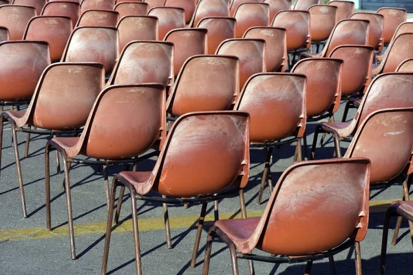 Composition with red plastic chairs, in auditorium in the open air, without public