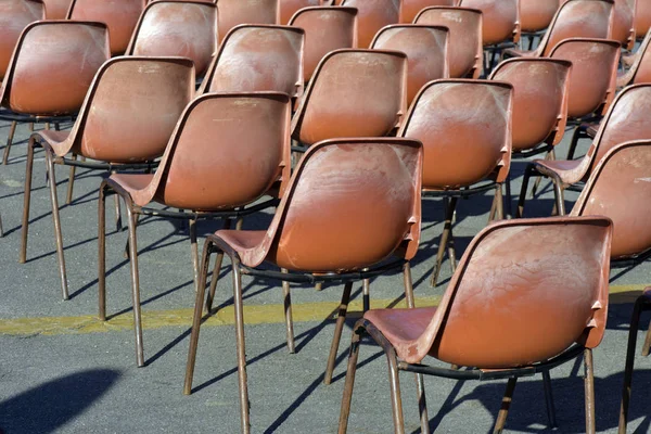 Composition with red plastic chairs, in auditorium in the open air, without public