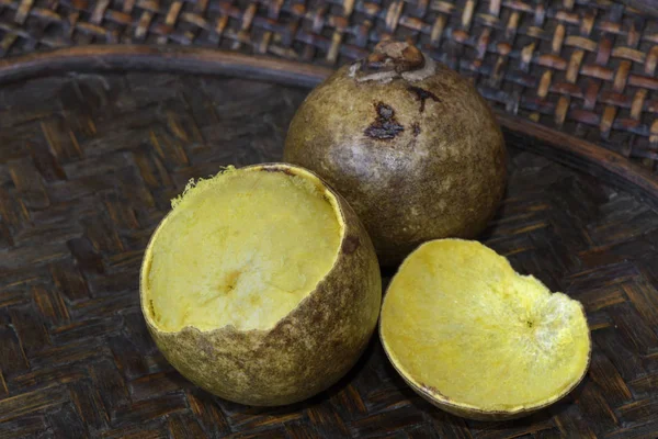 Brazilian fruit: stack of macauba on darkened wicker basket. Fruit palm is consumed in natura and produces excellent edible and industrial oils, including biodiesel