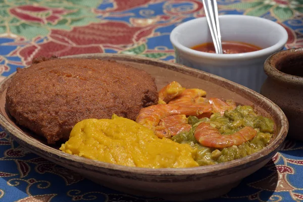 Brazilian food: acaraje on the plate with typical fillings, in table of regional food restaurant