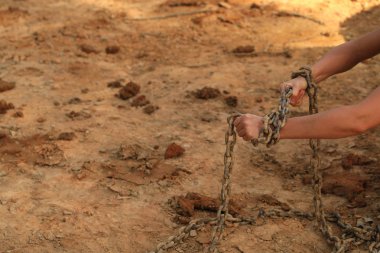 kumsala karşı eski paslı zincire insan eli