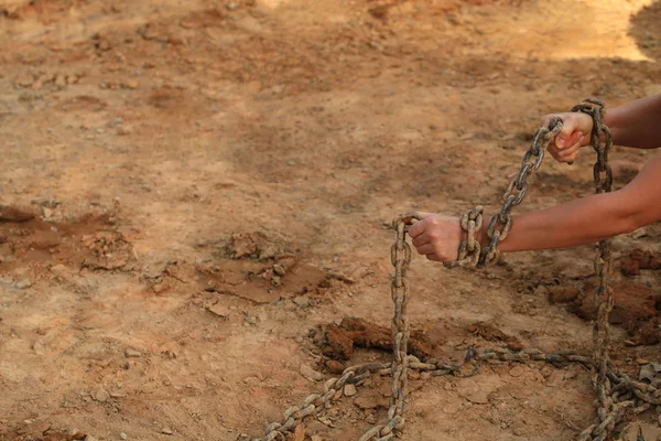 kumsala karşı eski paslı zincire insan eli