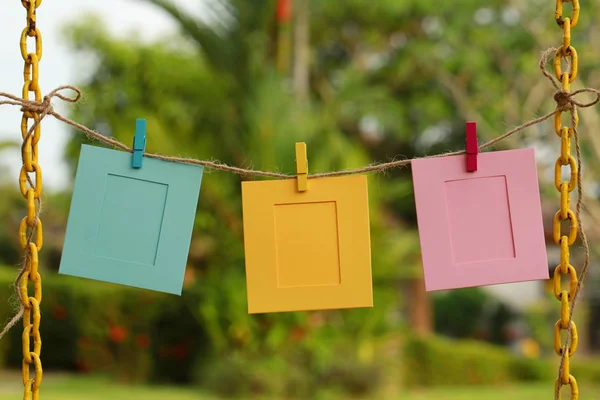 three colorful frames hanging on rope, close up