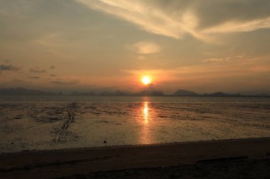 dağlar ile deniz üzerinde turuncu gün batımı ile kıyı şeridi görünümü 