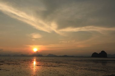dağlar ile deniz üzerinde turuncu gün batımı ile kıyı şeridi görünümü 