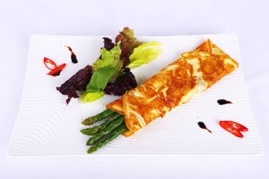 Kızarmış yumurta ve sebzeli kuşkonmaz.