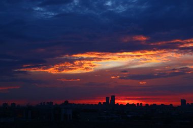 Günbatımı gökyüzü modern şehir binaları üzerinde.