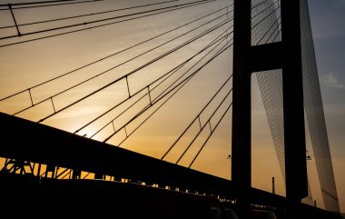 Gün batımında köprü kablolarının düşük açılı görüntüsü.