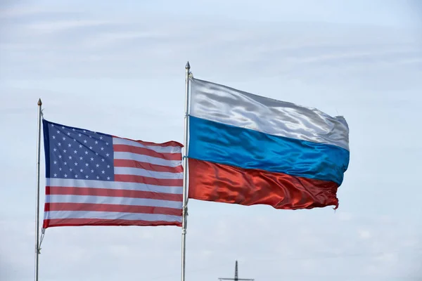 Usa Och Ryssland Flaggor Viftar Stolpar Med Moln Bakom — Stockfoto