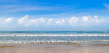 Hint Okyanusu'nun ıssız kumsalı. Mavi gökyüzünde pitoresk cumulus bulutları. Geniş fotoğraf.