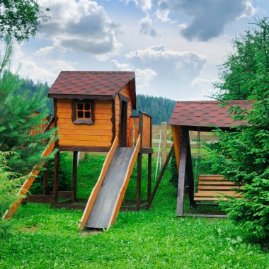 Bir tepe ve merdiven ve bir salıncak çocuk dinlenme için ahşap bir ev oynamak.