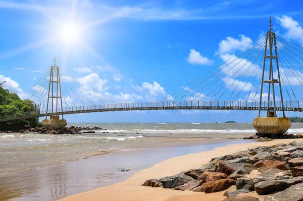 Bridge to island, ocean and sun in blue sky (Matara, Sri Lanka). Explore the world's beauty.