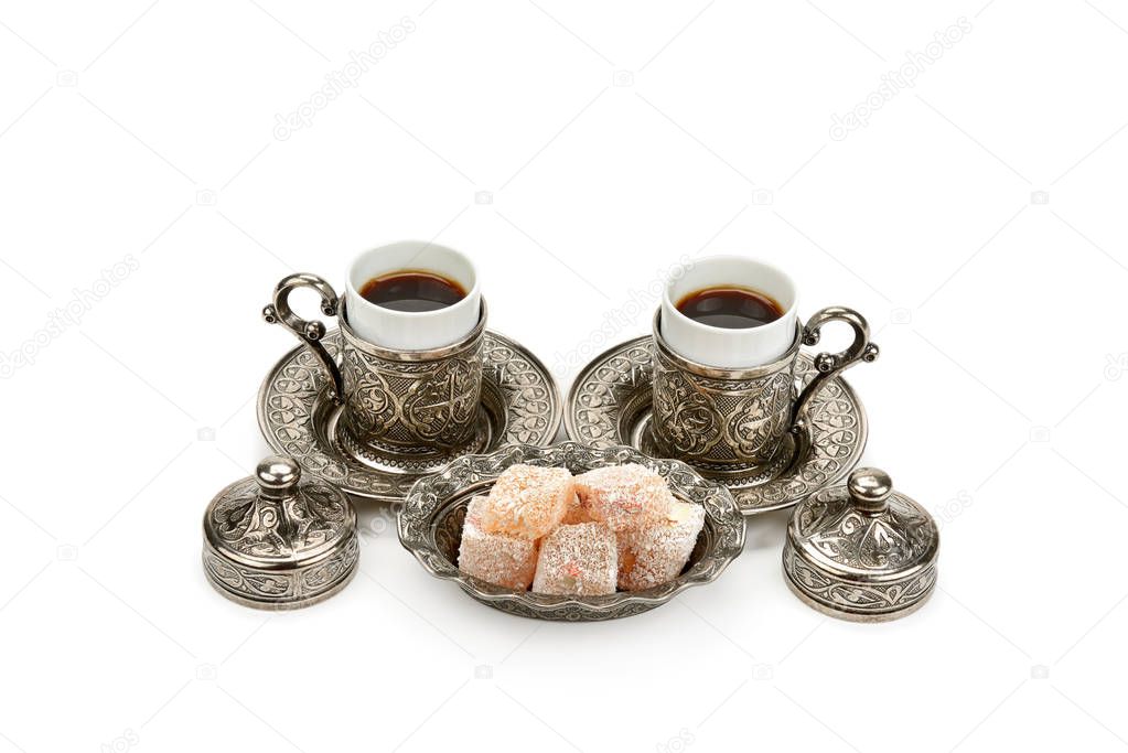 Cups of coffee and turkish delight in a vase isolated on white background.