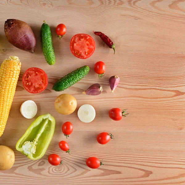 A set of vegetables laid out on a wooden table. Flat lay,top view. Free space for text.