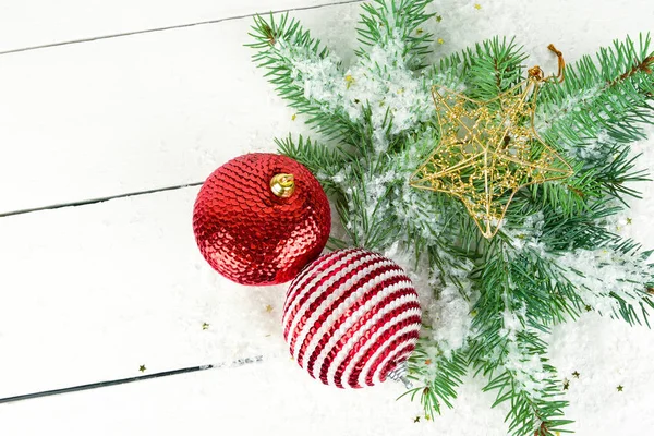 Las ramitas del abeto y adornos brillantes navideños sobre la madera blanca —  Fotos de Stock