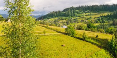 Dağlar ve akşam gökyüzünde bulutlar yamaçları. Geniş fotoğraf.