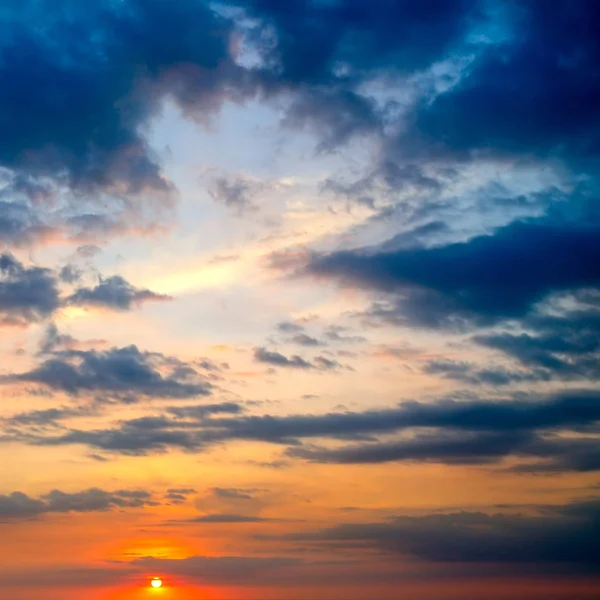 Bewolkte hemel en felle zon stijgen boven de horizon. — Stockfoto