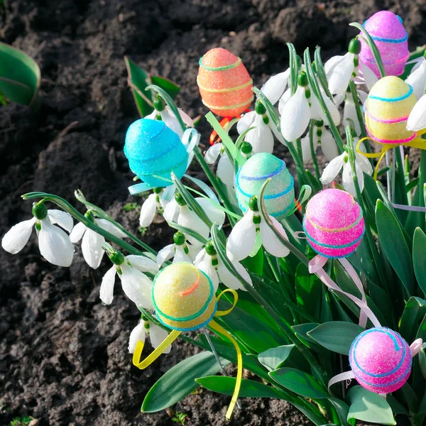 Белоснежные подснежники и декоративные яйца на весеннем фоне. E — стоковое фото