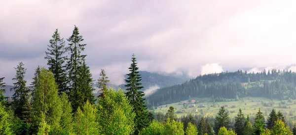 Berghänge und Wolken am Abendhimmel. breites Foto. — Stockfoto