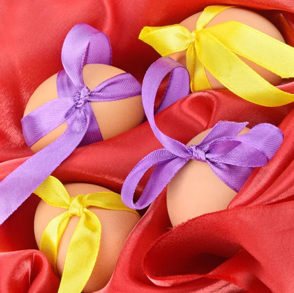Œufs de Pâques sur un tissu satiné rouge . — Photo
