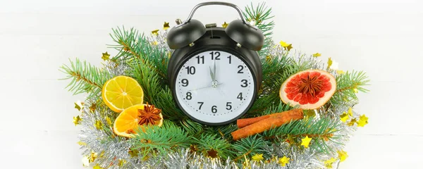 Часы, еловые ветви, специи, ломтики апельсинов на белой оси — стоковое фото