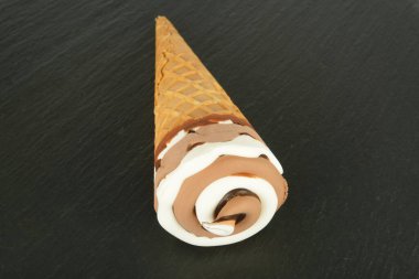 Siyah arka planda çikolatalı vanilyalı dondurma külahı..