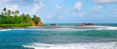 Etrafta palmiyeler olan güzel tropikal plaj manzarası. Tatil ve tatil konsepti. Geniş resim.