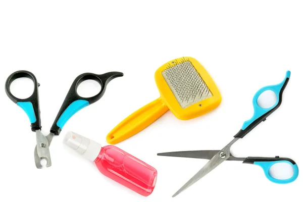 Pet supplies. Scissors, clipper, shampoo and comb for dog grooming isolated on a white background.