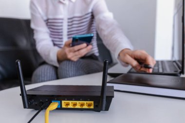 Ofiste telefon kullanan kablosuz yönlendirici ve kadın. router kablosuz geniş bant ev dizüstü bilgisayar telefon kablosuz telefon kavramı