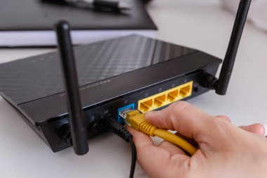  Kadın internet kablosunu yönlendiricinin prizine bağlıyor. Hızlı ve kablosuz internet konsepti