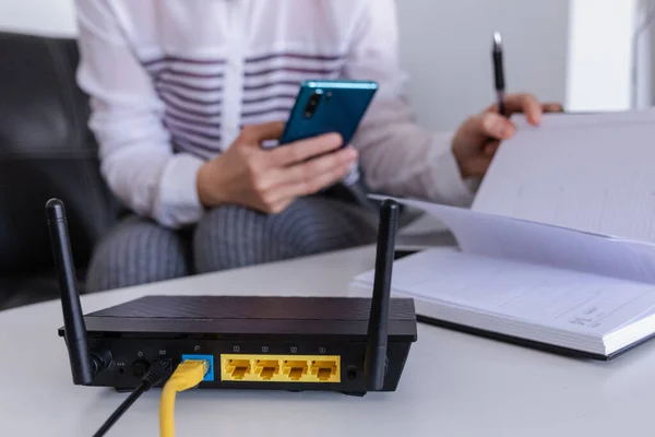 Ofiste telefon kullanan kablosuz yönlendirici ve kadın. router kablosuz geniş bant ev dizüstü bilgisayar telefon kablosuz telefon kavramı