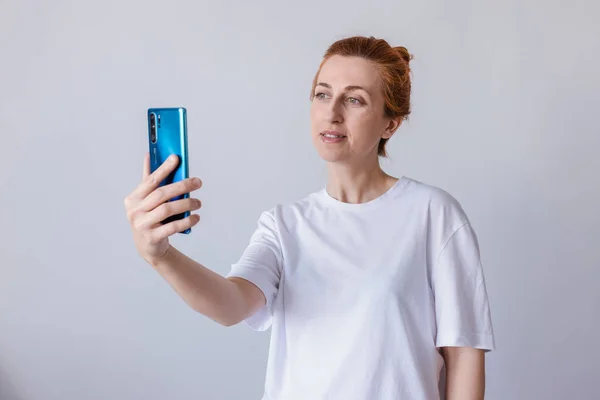 Женщина Улыбается Носит Белую Футболку Используя Мобильный Телефон Изолированный Белом Стоковая Картинка