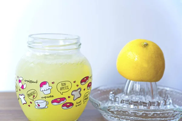 Lemon juice with lemon squeezer, white background