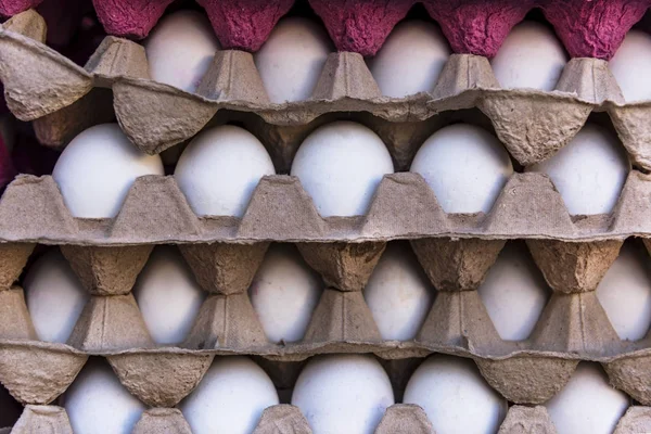 White eggs in a large egg boxes on a market stall, close up, details
