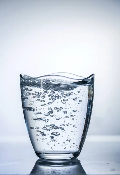 Lots of bubbles on glass of water on a  white background, isolated, macro photography