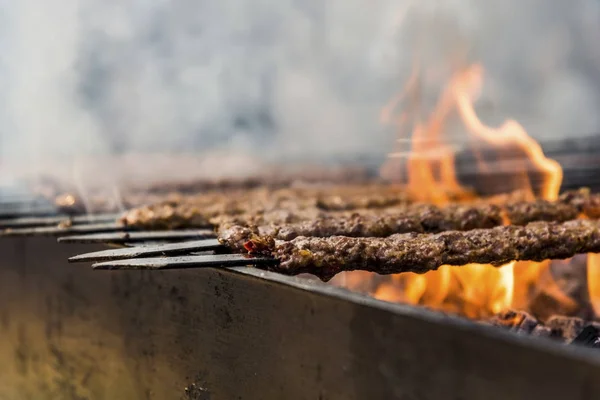 Adana-Türkiye ' d a portakal çiçeği Karnavalı 'nda turuncu renkli alev ve sigaraları olan bir barbekülü geleneksel Adana Kebap