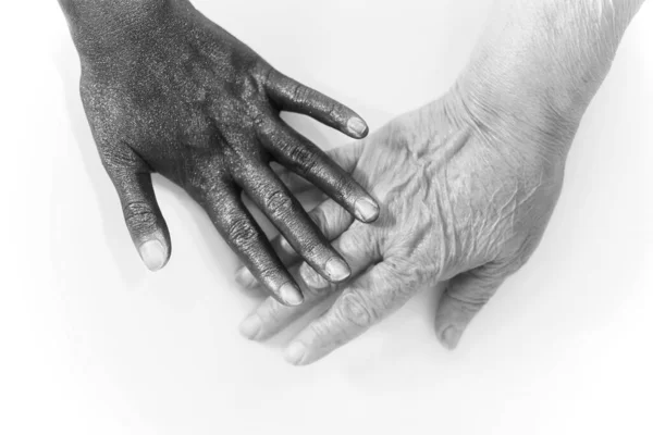Black hand touching a white hand for peaceful coexistence in the world, close up, abstract photography, isolated