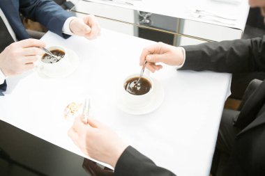 Cafe masa başına oturmuş, siyah kahve içme ve konuşmayı iki işadamları görünümünü