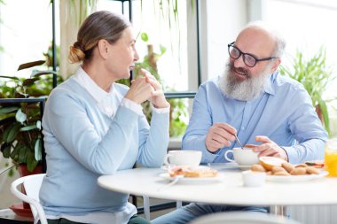 Cafe masa başına oturmuş, konuşmayı ve Çerezler ile çay içme Modern üst düzey çift