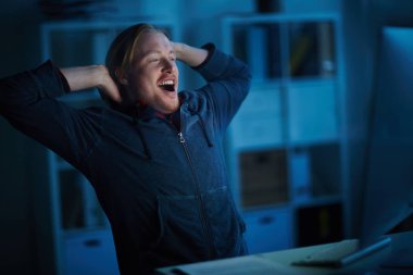 Ofiste bilgisayar üzerinde çalışırken esneme işadamı