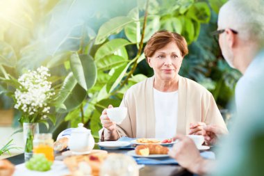 Yaşlı karısı kocası otururken her iki ev bahçesinde servis masasının söylüyorum dinlerken kahve ile