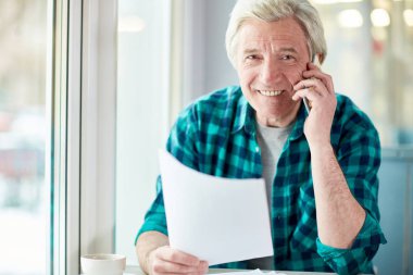 Yaşlı komisyoncu veya Ajan smartphone ve kameraya müvekkilinin için sözleşme noktaları açıklayan süre seyir kağıt ile