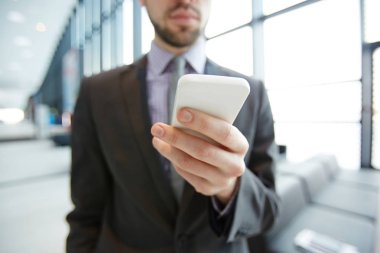 Onun smartphone içinde seyahat sırasında mesajlaşma çağdaş mobil iş adamı