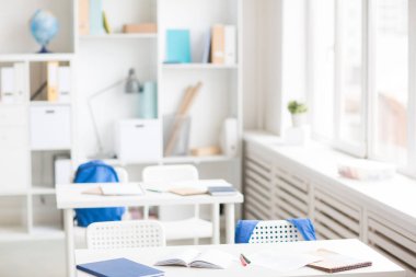 Satır masalarının ile okul malzemeleri, sandalye ve öğrencilerin okulda boş sınıfta sırt çantaları