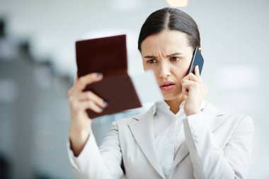Gergin işkadını pasaport ve uçuş biletini havaalanında smartphone ile konuşurken arıyorsunuz