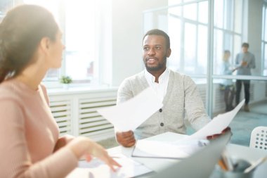 İki genç emin ekonomistler finansal kağıtları veya yeni iş sözleşmeleri toplantısında tartışmak